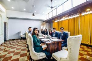 a group of people sitting around a table in a restaurant at FabHotel Golden Temple Paradise - 50 meters from Golden Temple in Amritsar