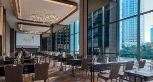 una sala de conferencias con mesas y sillas y una pantalla de proyección en Amari Kuala Lumpur, en Kuala Lumpur