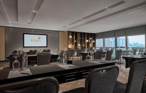 a conference room with tables and chairs and a screen at Amari Kuala Lumpur in Kuala Lumpur +99 photos