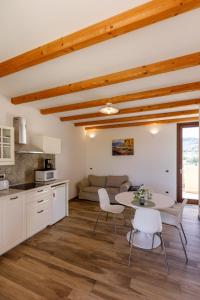 eine Küche und ein Wohnzimmer mit Tisch und Stühlen in der Unterkunft Residence Rustico in Garda