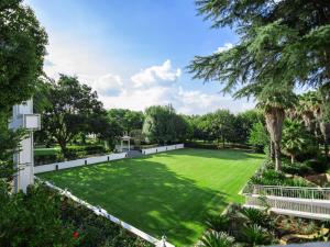 un gran césped con una valla blanca y árboles en Gracia de Dios, en Benoni