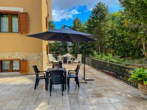 a patio with a table and chairs and an umbrella at Casa Vacanze - Villa Stefania in Pescocostanzo