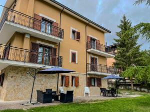 Casa Vacanze - Villa Stefania في بيسكوكوستانزو: مبنى امامه طاولات ومظلات
