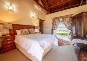 a bedroom with a large bed and a window at Trumpetters Drift Private Wildlife Lodge in Grahamstown +62 photos