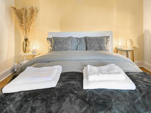 a bedroom with a large bed with two towels on it at Novena - Uk50586 in Penrith