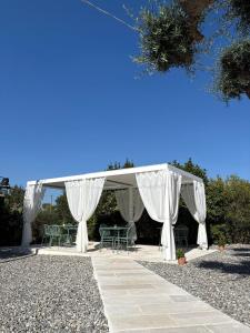 a white gazebo with chairs and tables under it at Trulli Pastore in Alberobello