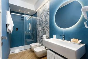 a bathroom with a sink and a toilet and a mirror at Hotel Calliope in San Vito lo Capo +27 photos