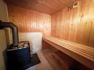 a sauna with a wood paneled walls and a stove at Chalet Svanöy by Interhome in Grimeli