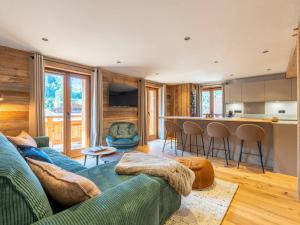 a living room with a couch and a kitchen at Bel appartement montagnard 3 chambres pour 6 avec parking au centre de La Clusaz - FR-1-459-245 in La Clusaz