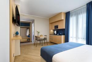 a hotel room with a bed and a table at Hotel Calliope in San Vito lo Capo