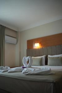 une chambre avec un lit avec des serviettes blanches dessus dans l'établissement Ada Newday Resort Hotel, à Kusadası