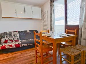 a dining room with a table and chairs and a couch at Studio cosy 3 places au pied des pistes, animaux acceptés - FR-1-340-124 in Chamrousse