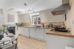 une cuisine avec des placards blancs et une cheminée dans l'établissement Boutique central Winchester Abode, à Winchester