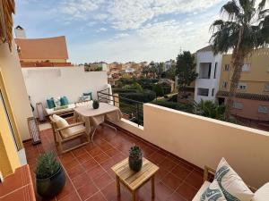 ベラにあるNaturist Paradise by the Beachのバルコニーにテーブルと椅子が置かれたパティオ