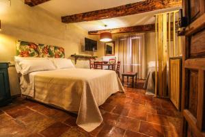 una camera da letto con un letto, un tavolo e delle sedie di Alfonso VIII 20 a Cuenca