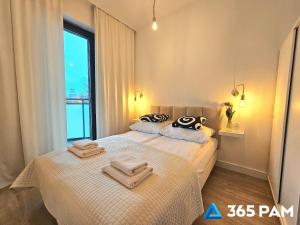 a bedroom with two beds with towels on them at 365PAM - Apartament Dobra Aura w Summer Lofts in Ustronie Morskie