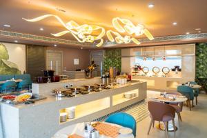 un restaurante con una gran cocina con mesas y sillas en Coral Reef Kakkanad, en Kochi