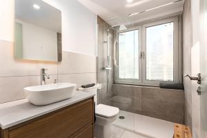 une salle de bain blanche avec un lavabo et des toilettes dans l'établissement Beachside apartment, à Sant Adrià de Besòs 22 autres photos