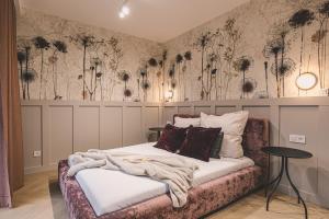 ein Schlafzimmer mit einem Bett mit Blumen an der Wand in der Unterkunft 2HomeRent Apartamenty Garbary 5 in Bydgoszcz