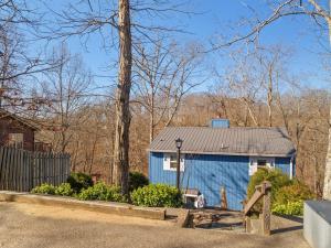 a blue shed with a silver roof in a yard at Little blue house on the lake in Nancy