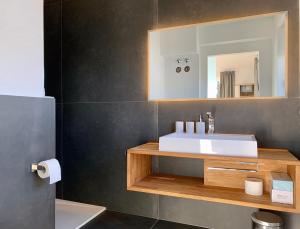 a bathroom with a white sink and a mirror at QC Quartier Chiemsee Hotel in Seebruck