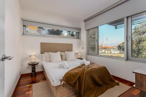 une chambre avec un lit avec des murs et des fenêtres blancs dans l'établissement Beachside apartment, à Sant Adrià de Besòs