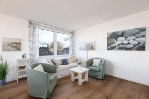ein Wohnzimmer mit einem Sofa, 2 Stühlen und einem Fenster in der Unterkunft Dorfring 36 Albatros in Stein