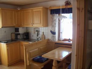 a kitchen with wooden cabinets and a table and a window at Haus Hinterseer in Schneizlreuth