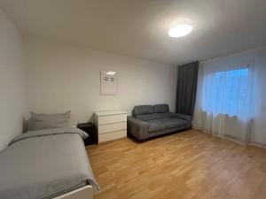 a bedroom with a bed and a chair and a window at Apartment Airport Dortmund in Holzwickede
