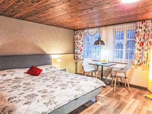 een slaapkamer met een bed, een tafel en stoelen bij Apartment Chalet Auf dem Vogelstein-1 by Interhome in Grindelwald