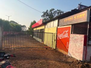 une clôture à côté d'un bâtiment avec une enseigne Coca-Cola dans l'établissement Hotel O Royal Stay, à Bilāspur 3 autres photos