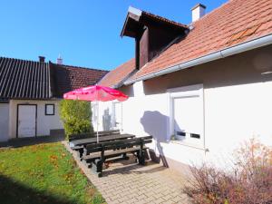 a picnic table with an umbrella next to a building at Holiday Home Friedl by Interhome in Ritzing
