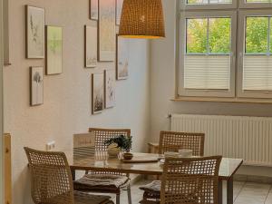 ein Esszimmer mit einem Holztisch und Stühlen in der Unterkunft "Unnen" in der Alten Schule Greetsiel in Krummhörn