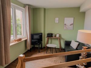 ein Wohnzimmer mit Sofa und Fernseher in der Unterkunft "Unnen" in der Alten Schule Greetsiel in Krummhörn