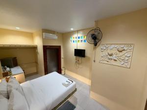 a room with a white bed and a fan at Khlong bang phra boutique hotel in Trat