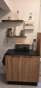 une cuisine avec un comptoir noir et une étagère dans l'établissement Studio Cosy entièrement rénové - Centre Historique, à Rochefort