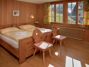 a bedroom with a bed and two chairs at Apartment Drei Tannen by Interhome in Wengen