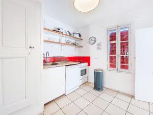 eine Küche mit weißen Schränken und roten Akzenten in der Unterkunft Holiday Home La Cadièrienne by Interhome in La Cadière-dʼAzur + 20 Fotos