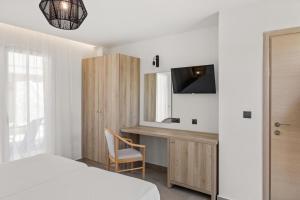 a bedroom with a bed and a desk and a tv at White Olive Marine Aquapark in Tigaki