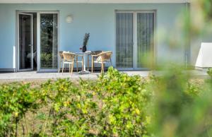 a house with a table and chairs on a patio at Apartment C2 - barrierefrei mit großer Südterrasse und Naturblick im "Pine Hill Resort" in Zirchow +35 photos