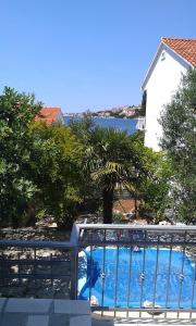 einen Pool mit einem Tor vor einem Haus in der Unterkunft Ferienhaus mit Terrasse und Kinderpool an einer Bucht mit Meerblick in Rogoznica