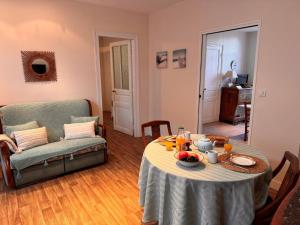 a living room with a table and a couch at Holiday Home Bel Air by Interhome in Cancale