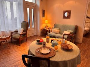 a living room with a table with food on it at Holiday Home Bel Air by Interhome in Cancale