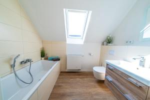 a bathroom with a tub and a toilet and a sink at Tweete Heimaat in Büsum +22 photos