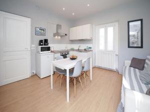 une cuisine avec une table et des chaises dans une pièce dans l'établissement Apartment Grigio by Interhome, à Germignaga 25 autres photos