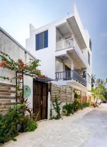 Un edificio blanco con balcón y flores. en Rasdu View Inn, en Rasdu