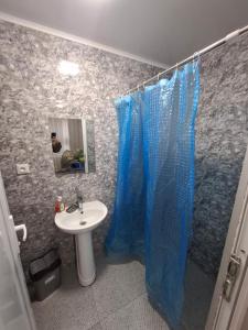 a bathroom with a sink and a blue shower curtain at Rusalka in Kobuleti +29 photos