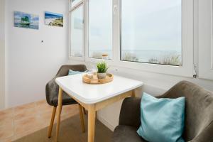 a living room with two chairs and a table and two windows at Strandbude in Laboe