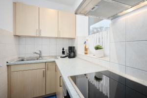 a kitchen with white cabinets and a sink at Strandbude in Laboe