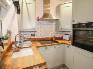 een keuken met witte kasten en een spoelbak bij 1 Nottingham Road in Southwell +6 foto's